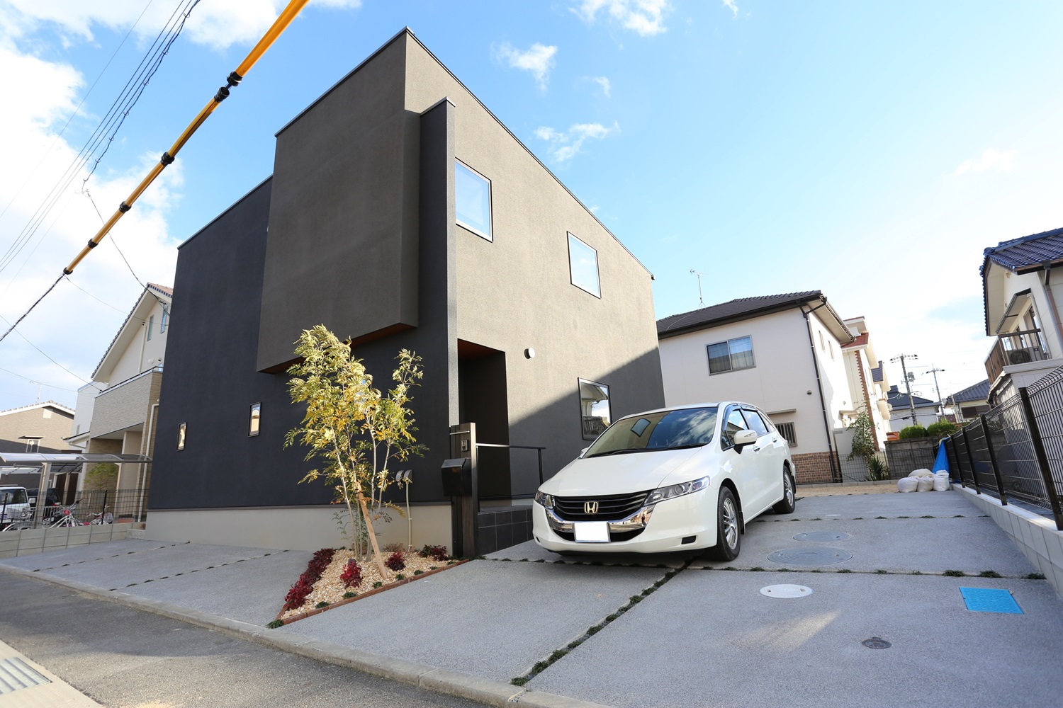 黒いシックな建物に映えるシンプル外構