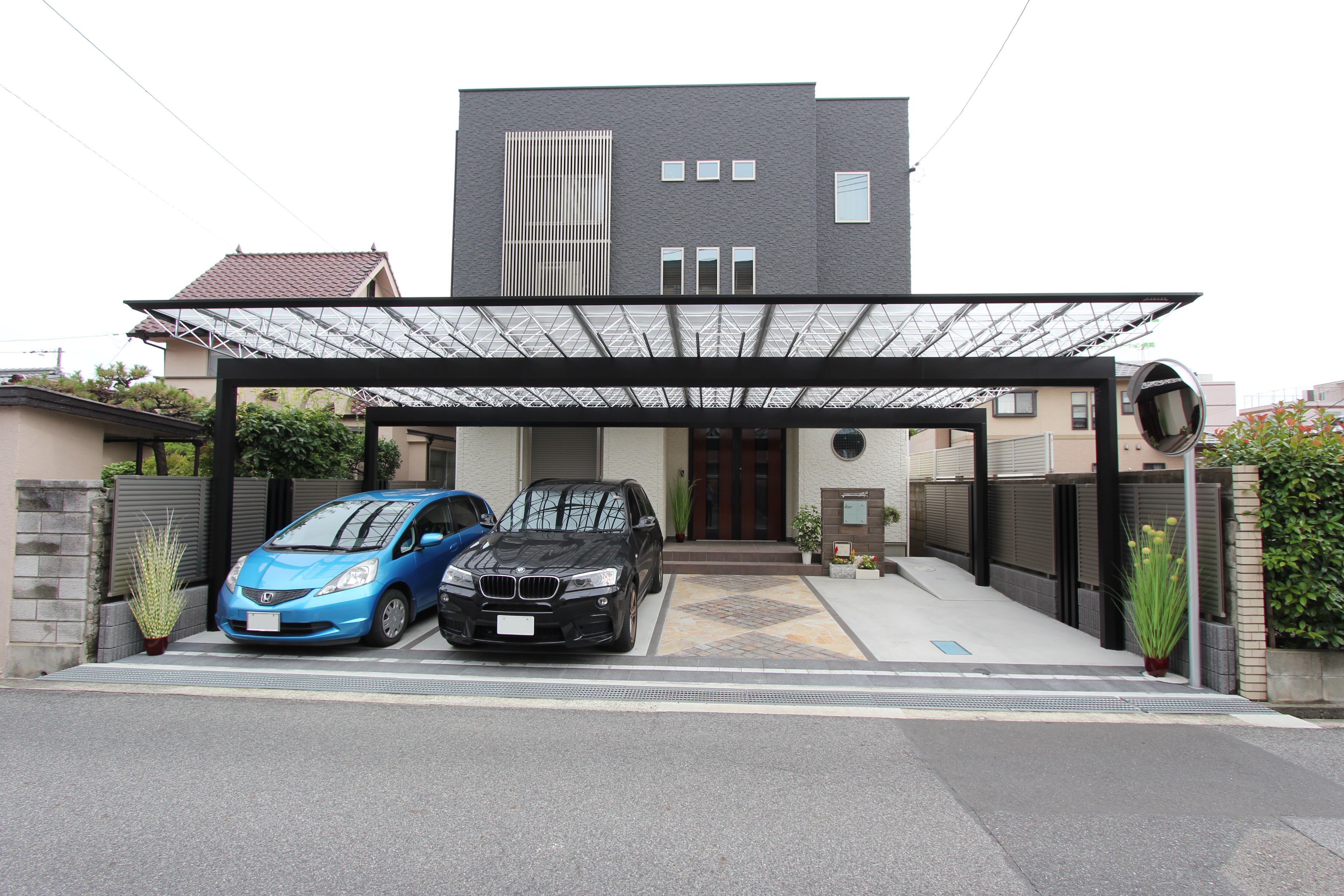 シックでシャープな黒色のカーポートで魅せる外構